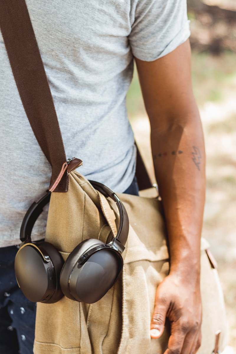 baton rouge man wearing brown crossbody bag with headphones hanged clothing